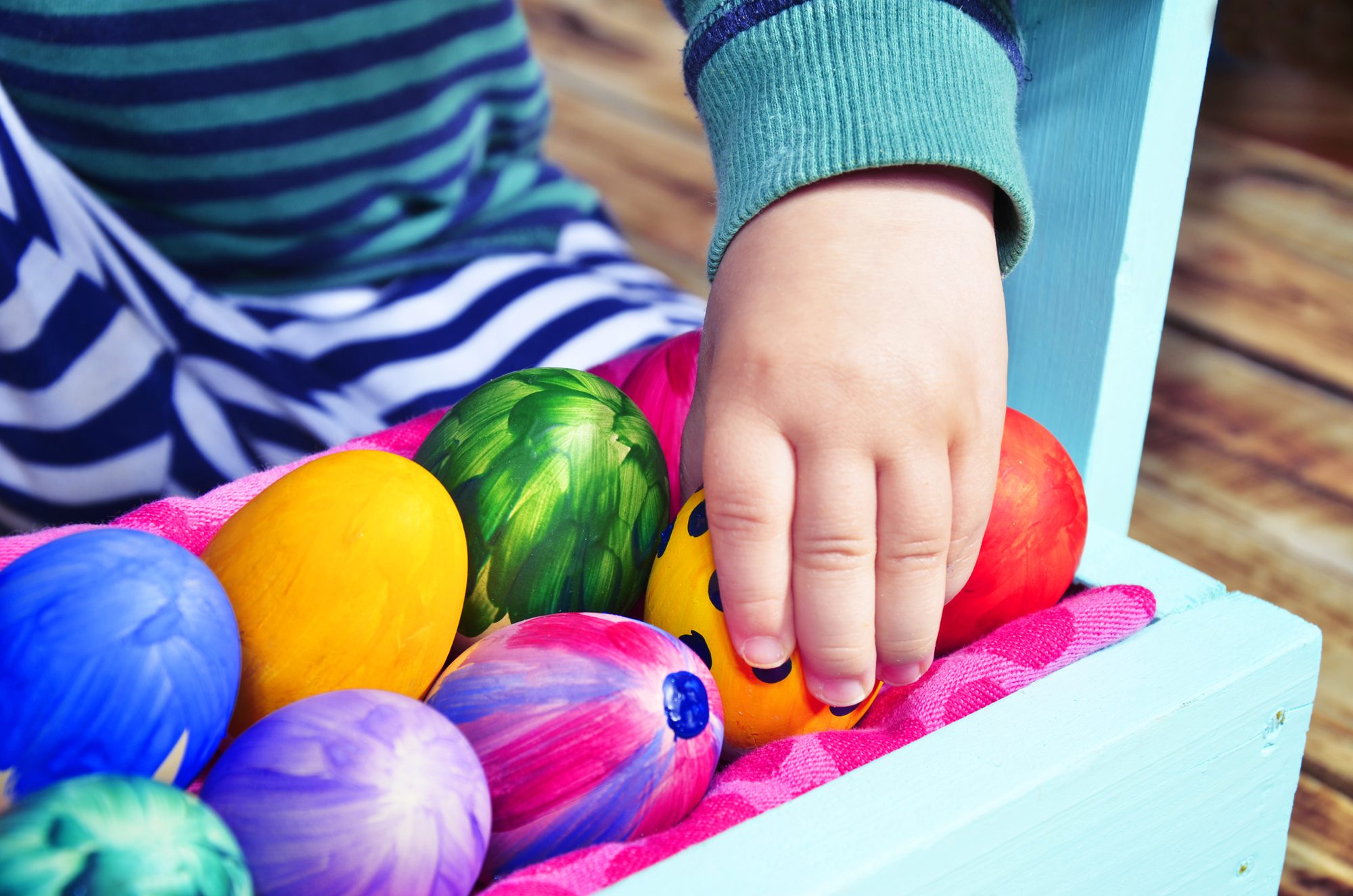 A child selecting painted eggs