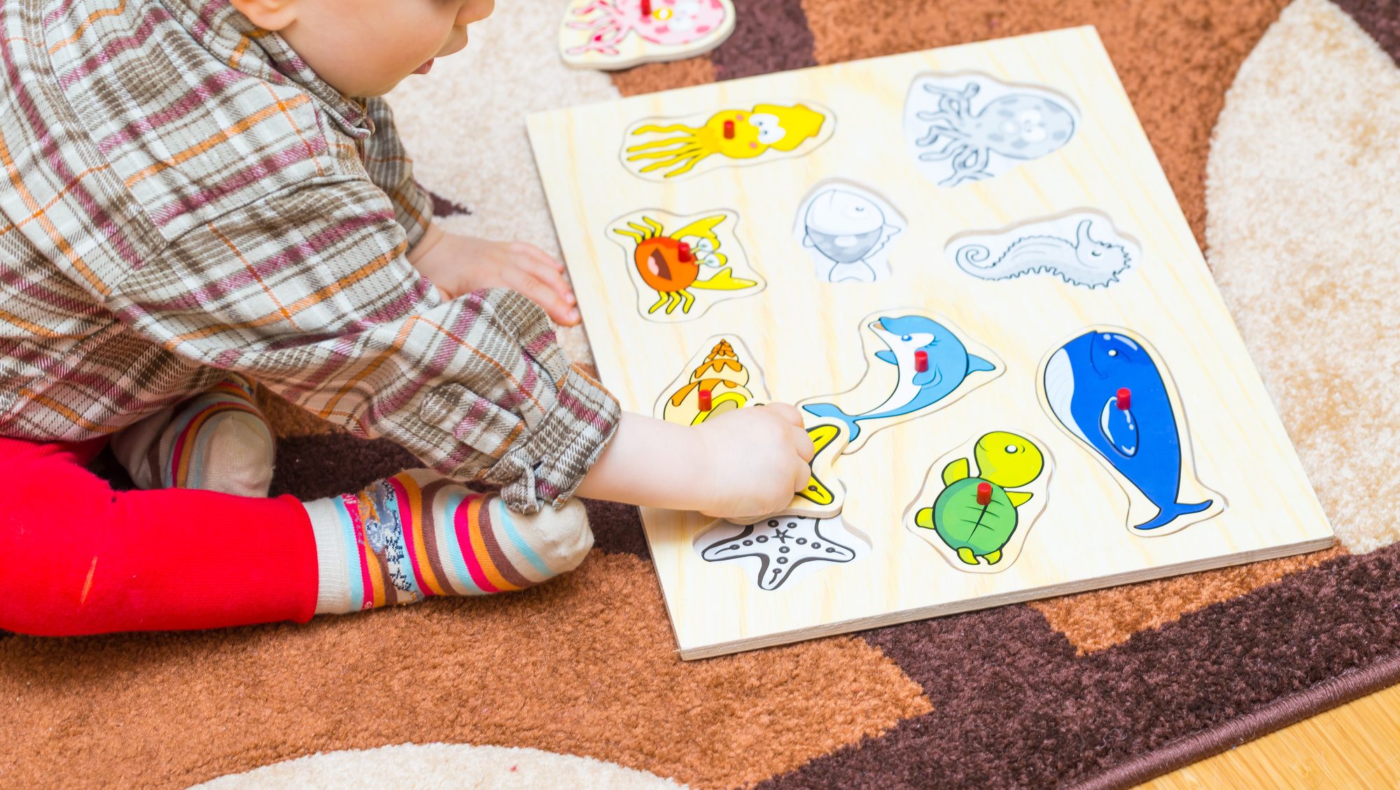 A toddler playing with a wooden puzzle