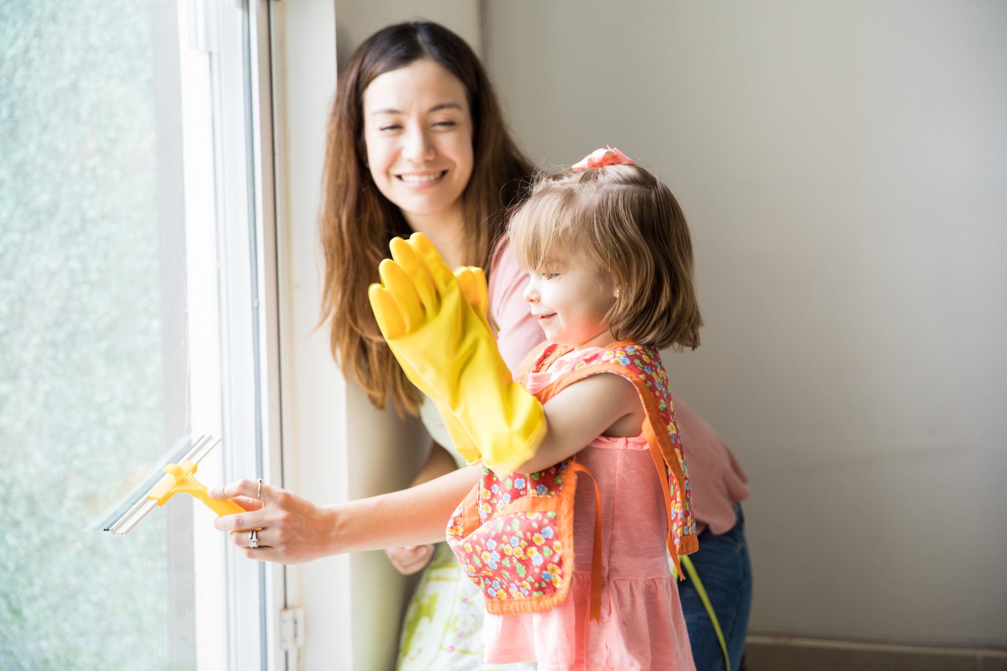 A mother and daughter cleaning a window
