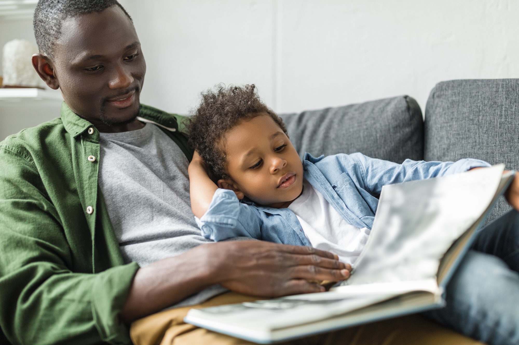 A father reading a book to a son