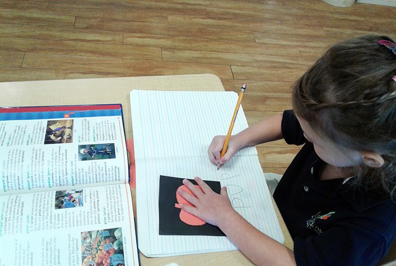 A student tracing letters at Meadow Montessori School in South Richmond, TX