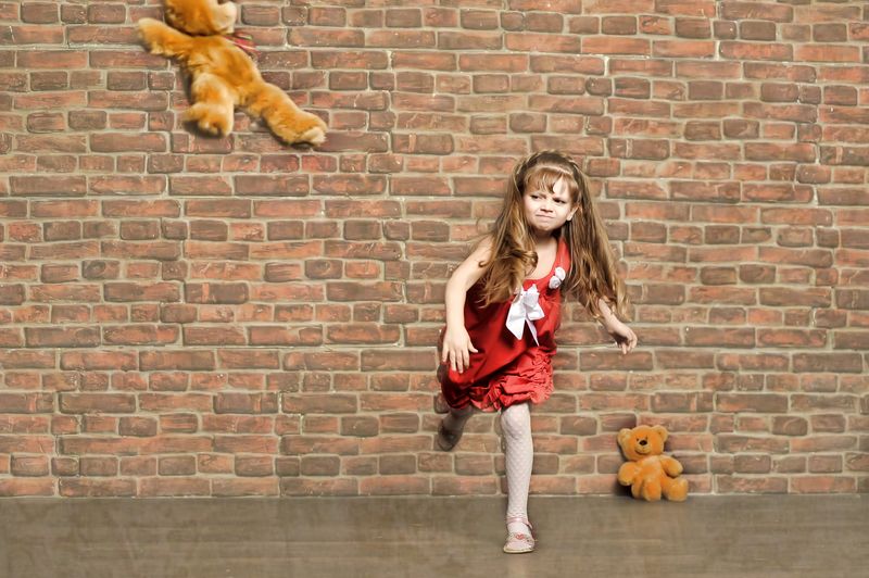Child throwing teddy bear