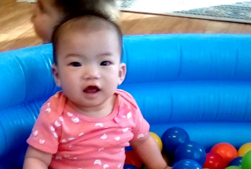 An infant playing a ball pit at Meadow Montessori School in South Richmond, TX