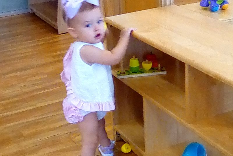 A toddler standing at a table at Meadow Montessori School in South Richmond, TX