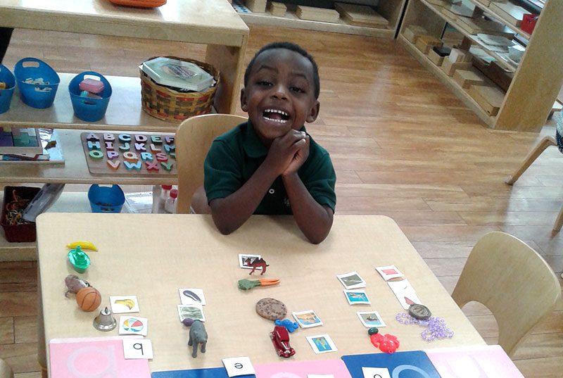 A young child playing with letters at Meadow Montessori School in South Richmond, TX