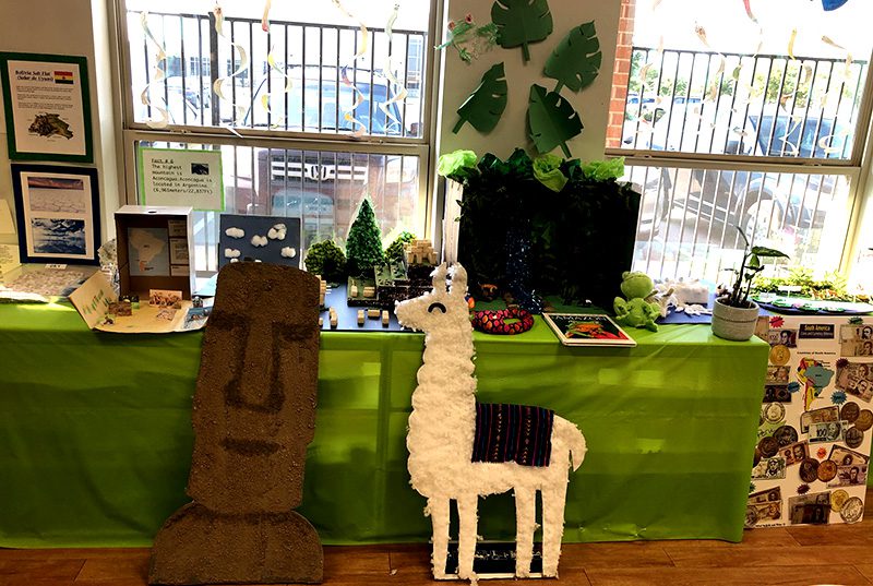 Llamas and Easter Island Head paper maches next to a table at Meadow Montessori School in South Richmond, TX