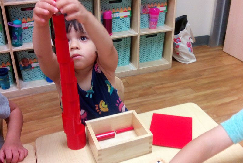 A girl at Meadow Montessori stacking blocks in South Richmond, TX