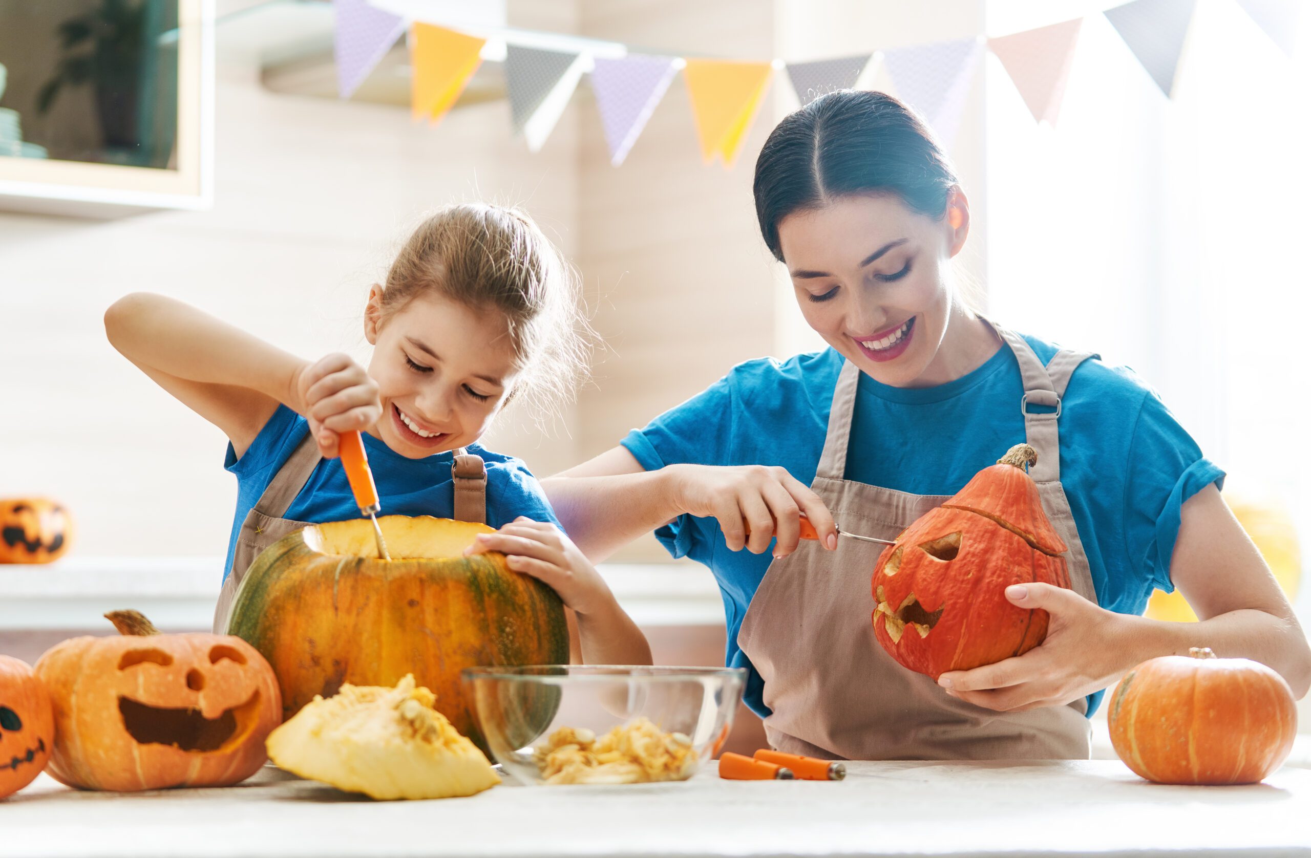 mother and daughter carving a pumpkin