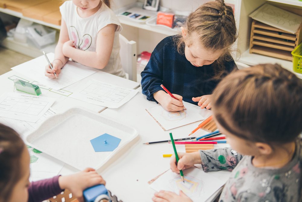 Children working at a table at a Montessori school