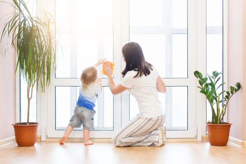 Mother teaching a child how to wash a window,practical life skills with Montessori learning