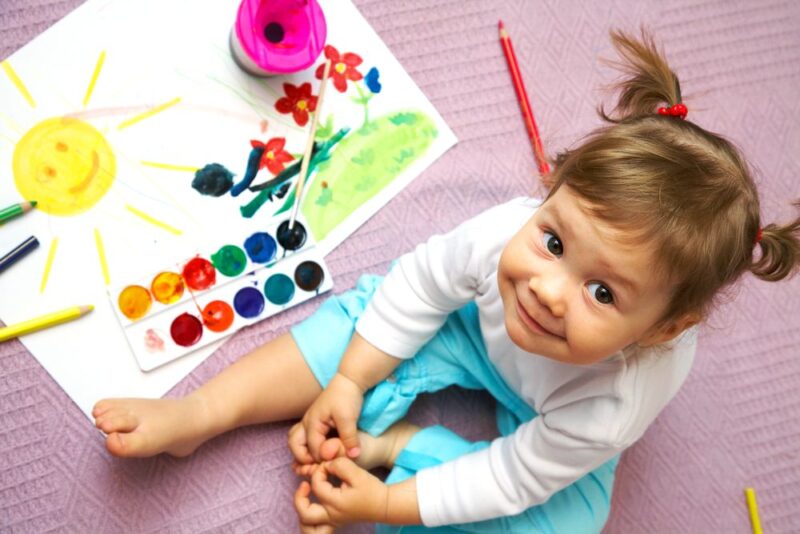 Montessori girl painting at home during the summer